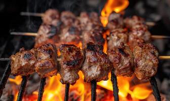 Skewers of lamb shashlik slowly turning over smoldering coals photo