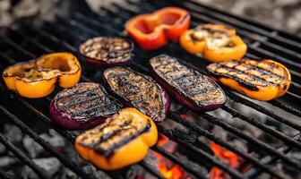 Thick slices of eggplant and peppers grilling over the hot coals photo