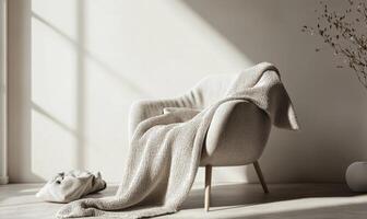 A chair with a blanket draped over it sits in a room with a window photo