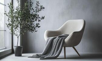 A white chair with a blanket draped over it sits in front of a window photo