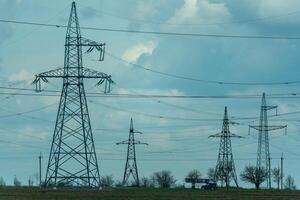 High voltage towers with sky background. Power line support with wires for electricity transmission. High voltage grid tower with wire cable at distribution station. Energy industry, energy saving photo