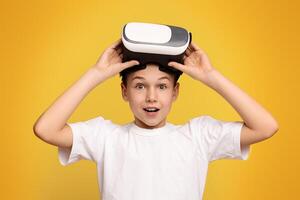A young boy is holding a device on his head, showcasing curiosity and engagement with technology. photo