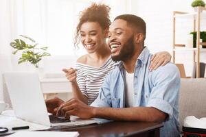 Searching tour. African-american couple using laptop, preparing for holidays photo