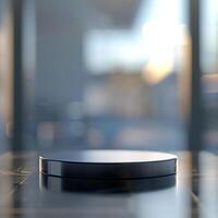 A black object on a table in front of a window photo