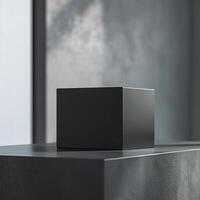 A black cube sitting on a table in front of a window photo