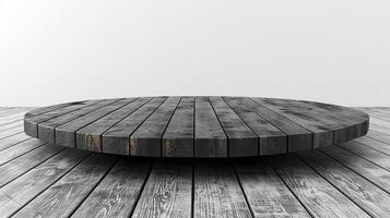 A black and white photo of a circular table on a wooden floor