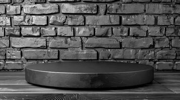 A black and white photo of a round table in front of a brick wall