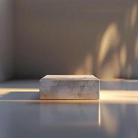 A white box sitting on a table in front of a wall photo