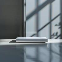 A white box sitting on a table in front of a window photo