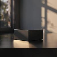 A black cube sitting on a table in front of a window photo