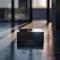 A black box sitting on the floor in front of a large window photo