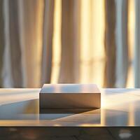 A white box sitting on a table in front of a window photo