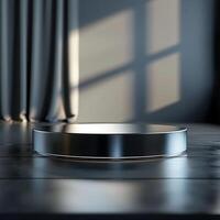 A round metal pedestal on a table in front of a window photo