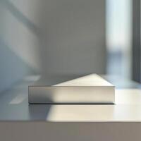 A white box sitting on a table in front of a window photo