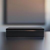 A black box sitting on a table in front of a blank wall photo