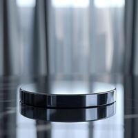 A black circular object on a table in front of a window photo