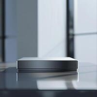 A silver box sitting on a table in front of a window photo