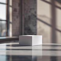 A white cube sitting on a table in front of a window photo