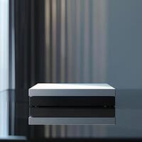 A white box sitting on a table in front of a window photo