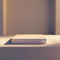 A white book sitting on a table in front of a window photo