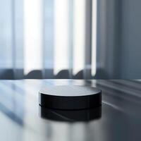 A black object sitting on a table in front of a window photo