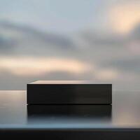 A black box sitting on a table in front of a cloudy sky photo