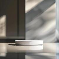 A white plate on a table in front of a window photo
