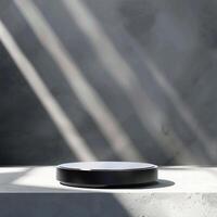 A black object sitting on a table in front of a wall photo