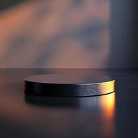A black round table with a light shining on it photo