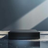 A black box sitting on a table in front of a wall photo