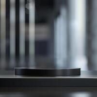 A black circular object on a table in front of a blurry background photo