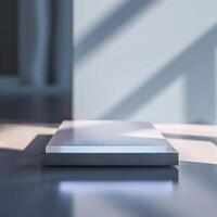 A white box sitting on a table in front of a window photo