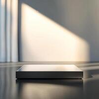 A white box sitting on a table in front of a window photo
