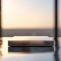 A silver box sitting on a table in front of a window photo