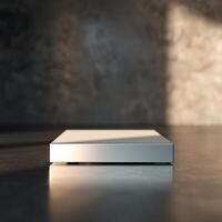 A white box sitting on a table in front of a wall photo