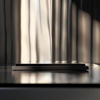 A black laptop on a table in front of a window photo