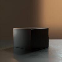 A black cube sitting on a table in front of a wall photo