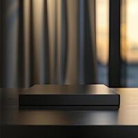 A black box sitting on a table in front of a window photo