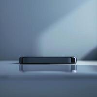 A black smartphone sitting on a table in front of a window photo