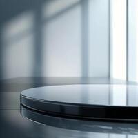 A glass table with a circular surface in front of a window photo