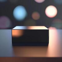 A black box sitting on a table in front of a blurred background photo