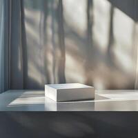 A white box sitting on a table in front of a window photo