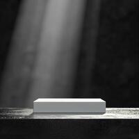 An empty white box sitting on a table in front of a dark wall photo
