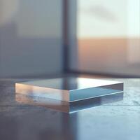 A glass cube sitting on a table in front of a window photo