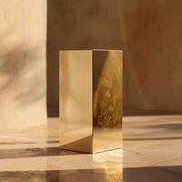 A golden cube sitting on a table in front of a wall photo