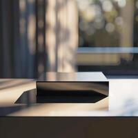 A black box sitting on a table in front of a window photo
