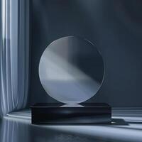 A glass trophy on a table in front of a curtain photo