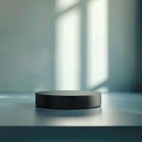 A black object sitting on a table in front of a window photo
