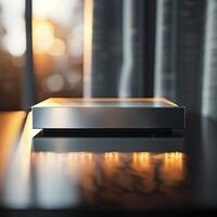 A silver box sitting on a table in front of a window photo
