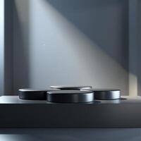 Three black round objects on a table in front of a wall photo